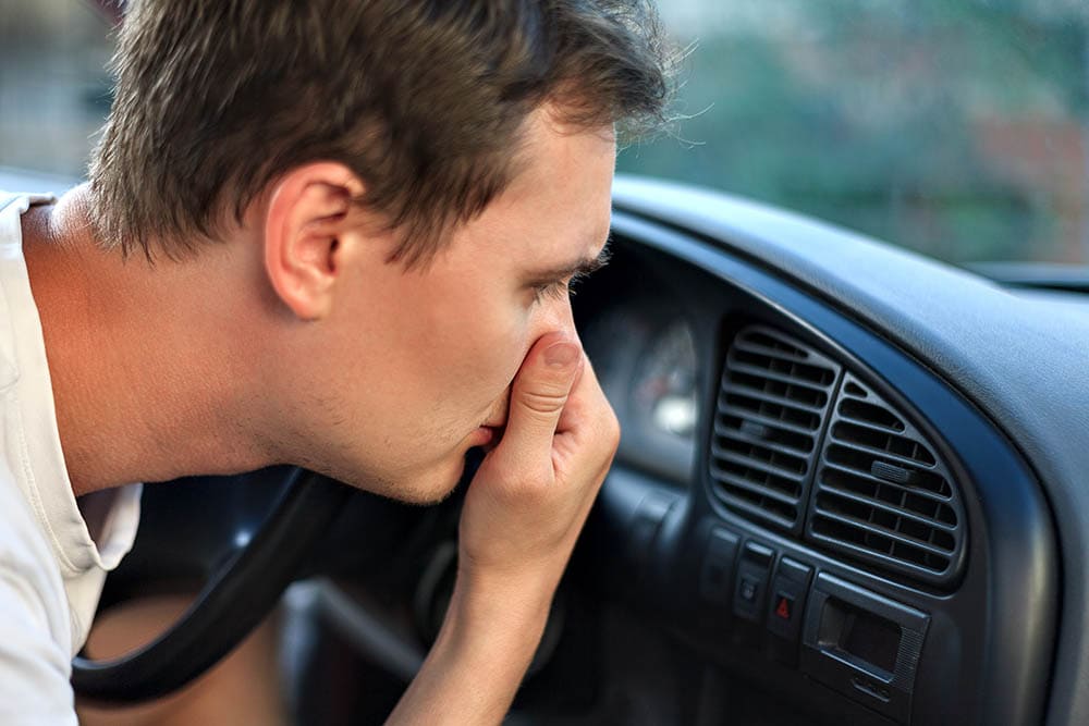 男人在车里捂着鼻子以防难闻的气味